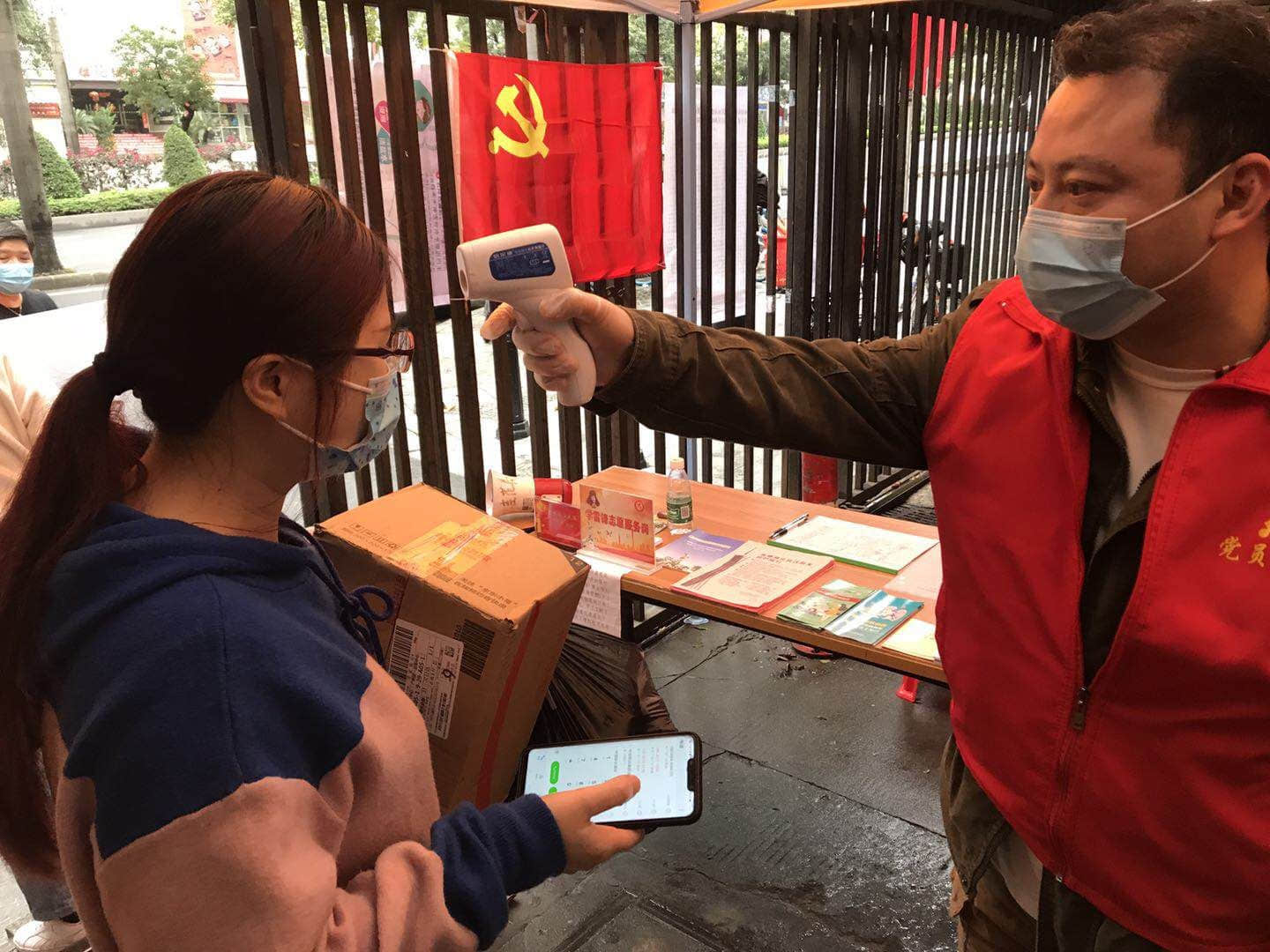 黨員志愿者冒雨為社區(qū)居民測溫