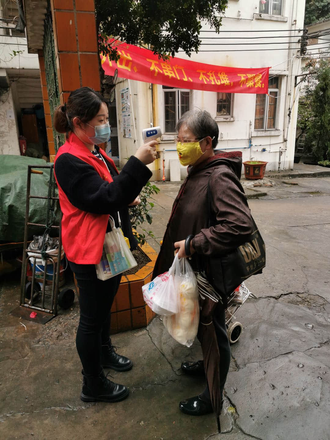 黨員志愿者冒雨為社區(qū)居民測溫