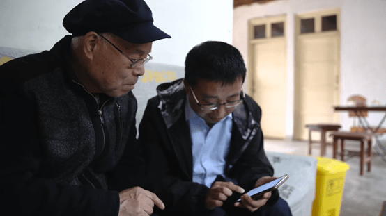 ▲ 在陜西西安，美團(tuán)優(yōu)選社區(qū)電商服務(wù)站站長正教老人使用手機(jī)下單。建偉?攝
